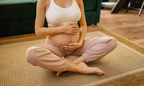 a pregnant women sitting on the floor and doing you
