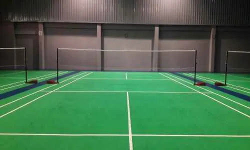 a pickleball court with net in a basement room
