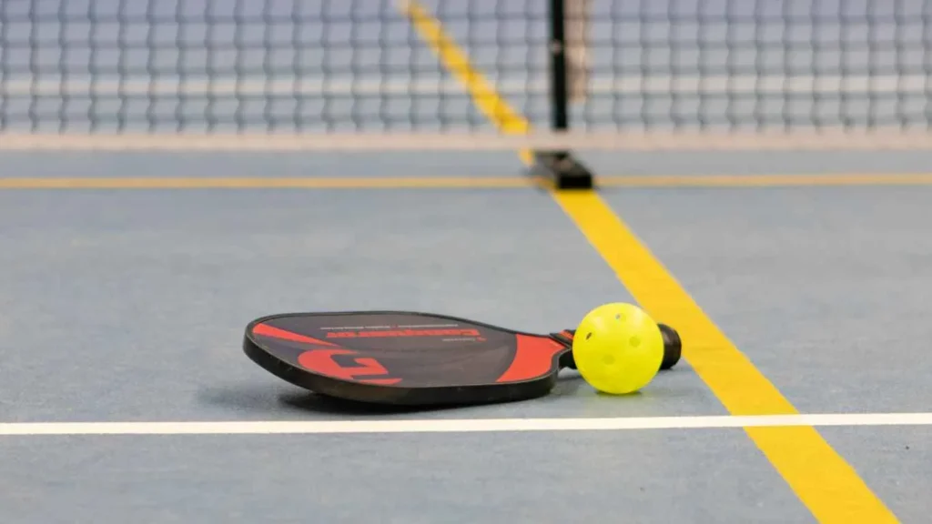 a paddle and pickleball on a Pickleball court