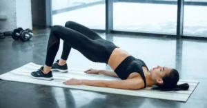 a women lying on her back on a mat and doing Basic Bridge Stretch